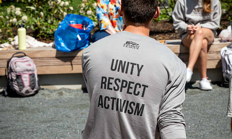 Male student wearing a shirt with the words"unity, respect, activism"