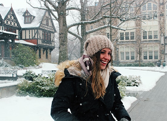Abigail Vitaliano standing in front of the Humanities Building on a snowy day