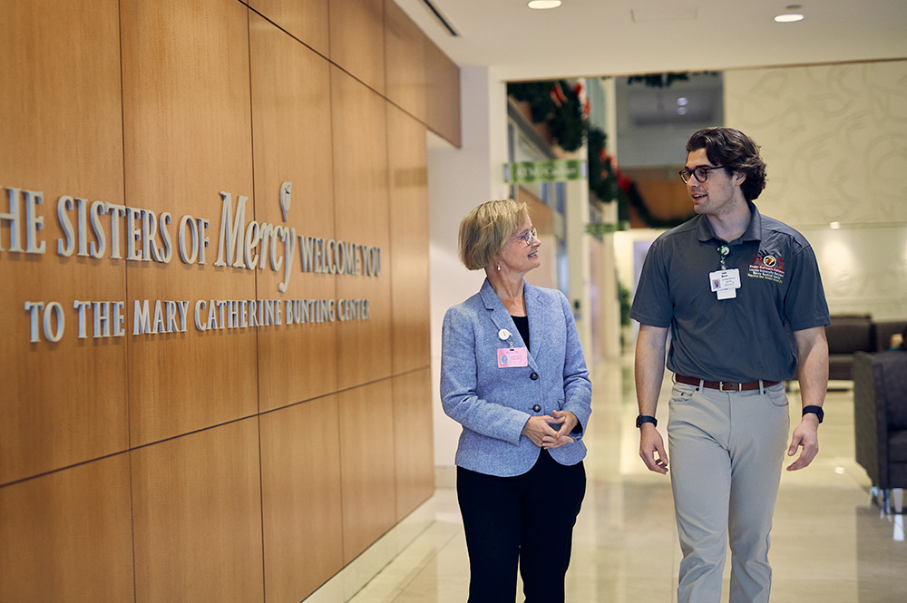 A student and Loyola administrator walking in Mercy hospital