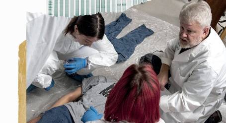 Professor and two students inspecting a mock crime scene and evidence