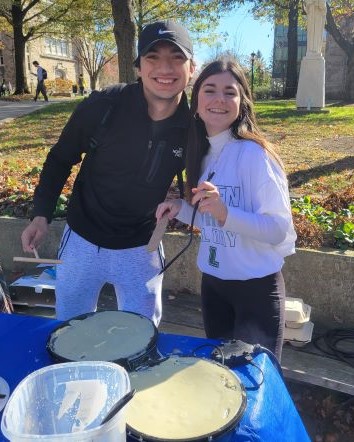 Two students posing for a picture while making crepes