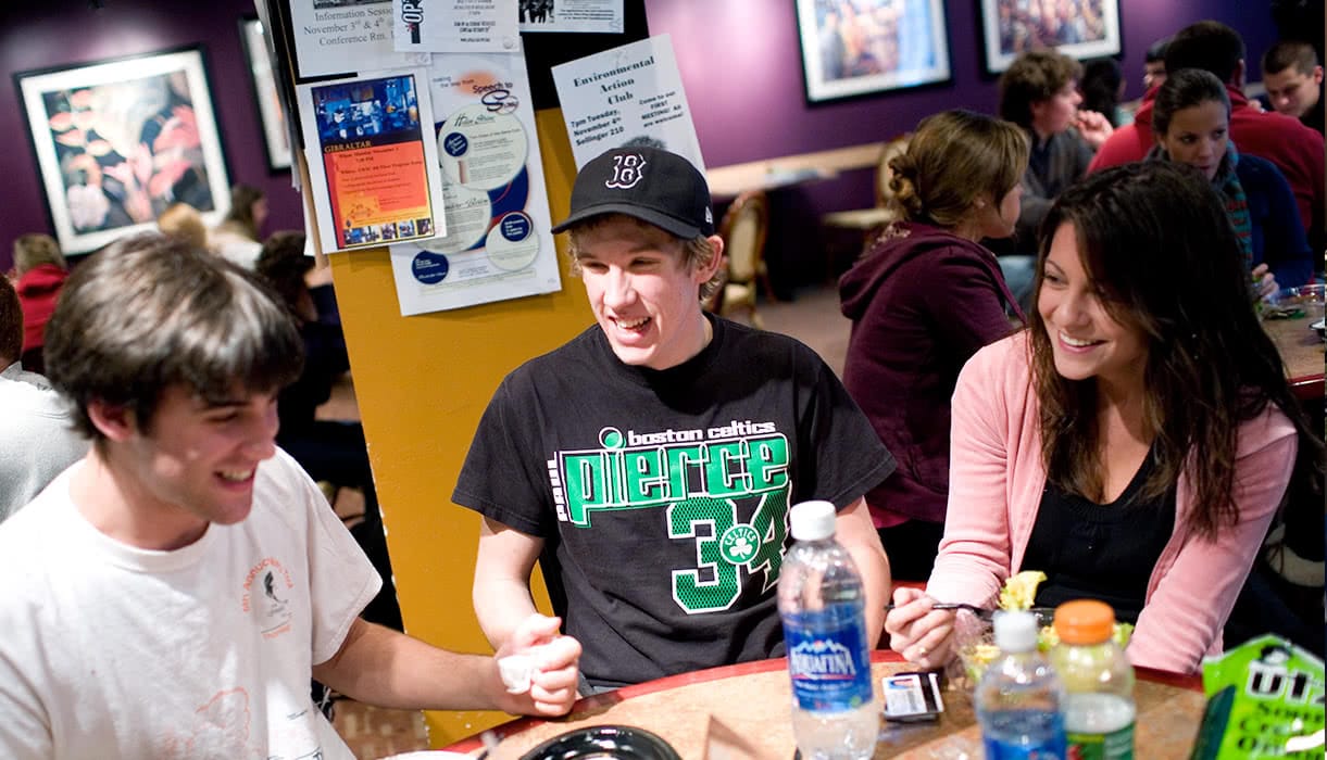 Students eating and laughing in a dining hall