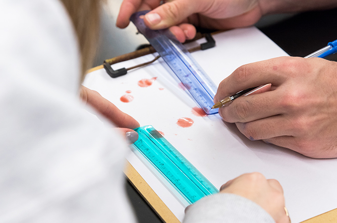 Students measure drops of blood for a lab assignment.