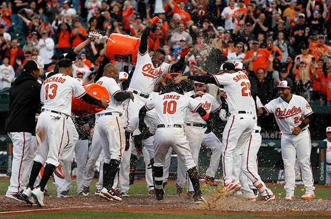 The Baltimore Orioles celebrating as a player jumps onto home plate after winning the game