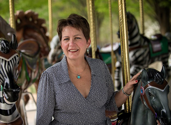 Nancy Noppenberger, MBA ’91 standing inside a carousel.