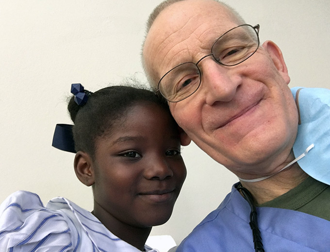 A Haitian child and dentist smile for a selfie