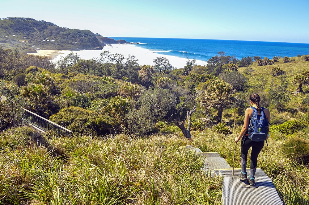 Study abroad student hiking towards a scenic beach in Sydney, Australia