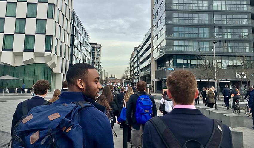 Students in suits with backpacks walking in a city in Ireland