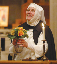 Sister Nancy Murray, O.P. holding a small bouquet of flowers and smiling