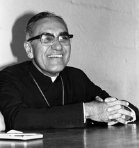 Oscar Romero laughing and smiling warmly with his hands folded at a table