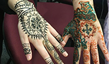 two hands decorated with henna designs
