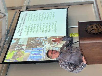 Dr. David Carey Jr. standing in front of projector screen