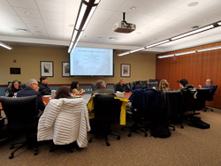 people around a table looking at a presentation