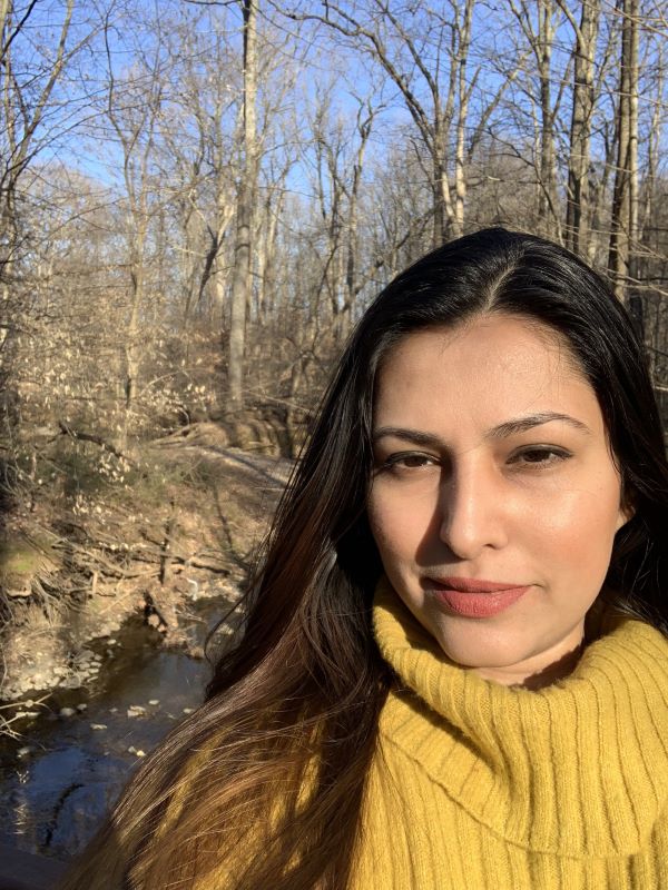 Aleezay in the woods wearing a yellow sweater