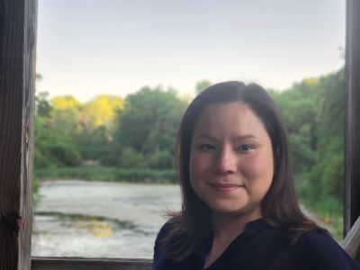 Karen Lin-Greenberg shoulders up portrait in front of lake