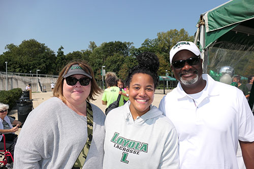 A student and her parents pose for a photo at a Loyola University athletic event 