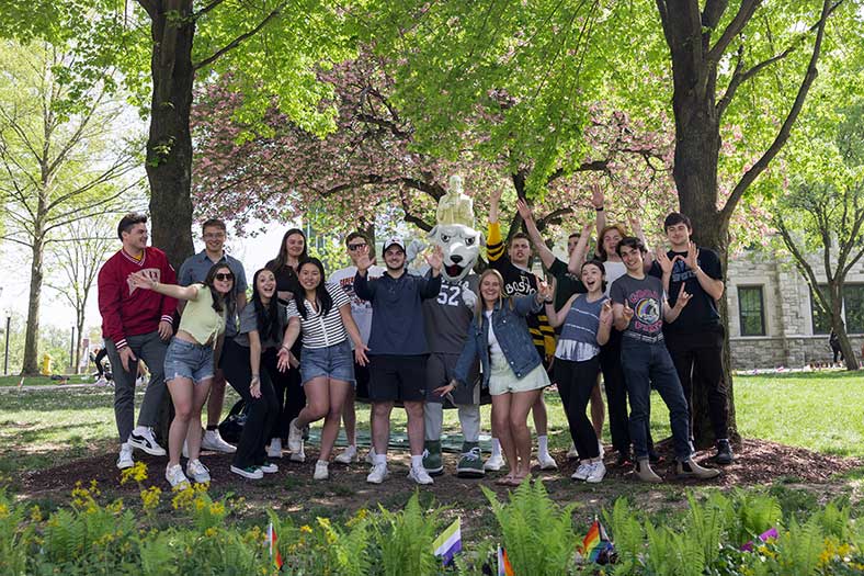 students stand on the Loyola University quad with Iggy on a spring day