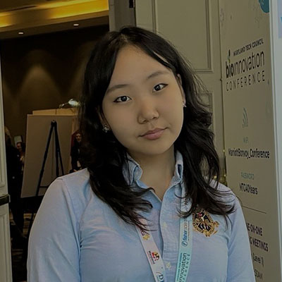 Anulin smiling for a photo at a science conference
