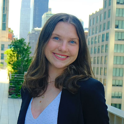 Shannon in professional attire on a high rise balcony in a city