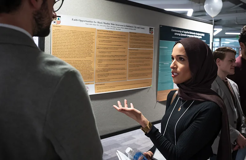 A student presenting a research poster