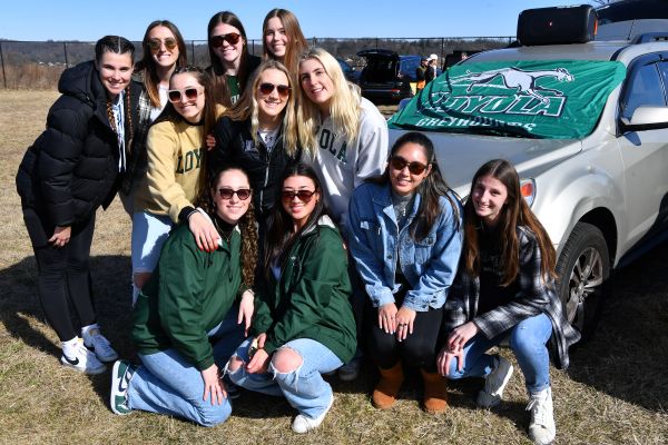 Photo of a group of young Loyola alumni tailgating at Ridley Athletic Complex