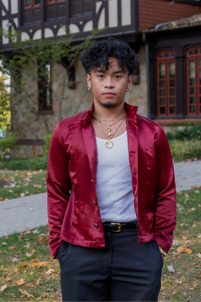 Male student posed in front of Loyola's Humanities porch in the fall season. 