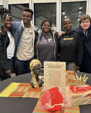 Five students pictured behind the Agege Bread table