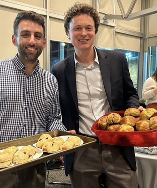 Two event attendees with trays full of different bread