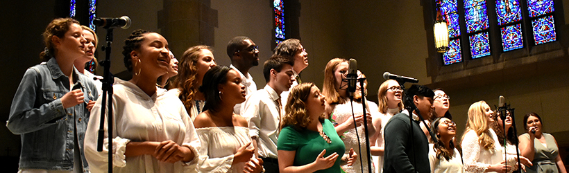 Students singing at front of chapel