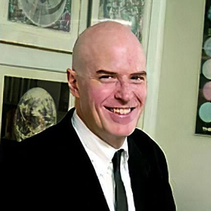 bald white man wearing suit and tie