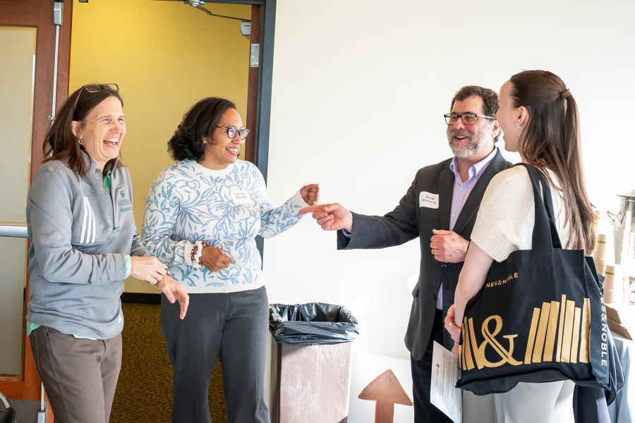 CRE Symposium photo of group of individuals laughing and talking at CRE Symposium 2025