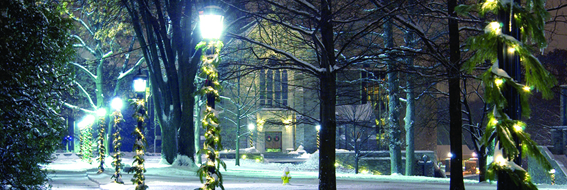 Holiday decor and snow on the Quad with Chapel in the background