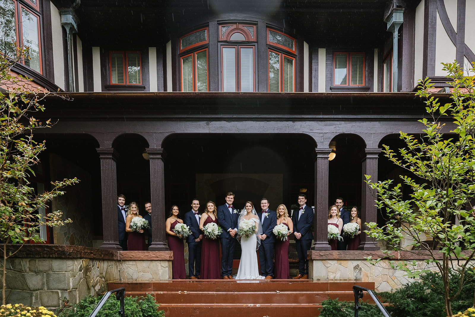 Bridal party poses on the porch of the Hug Lounge and Refectory. Urban Row Wedding 373. Photo credit ©️Urban Row Photography www.urbanrowphoto.com 