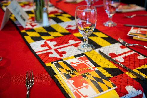 Table with red table cloth and Maryland themed runner with glassware.
