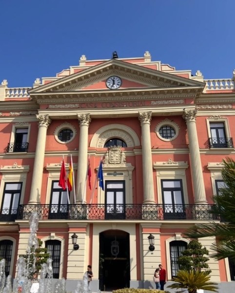 Red outside of a townhall building with red and yellow flags.