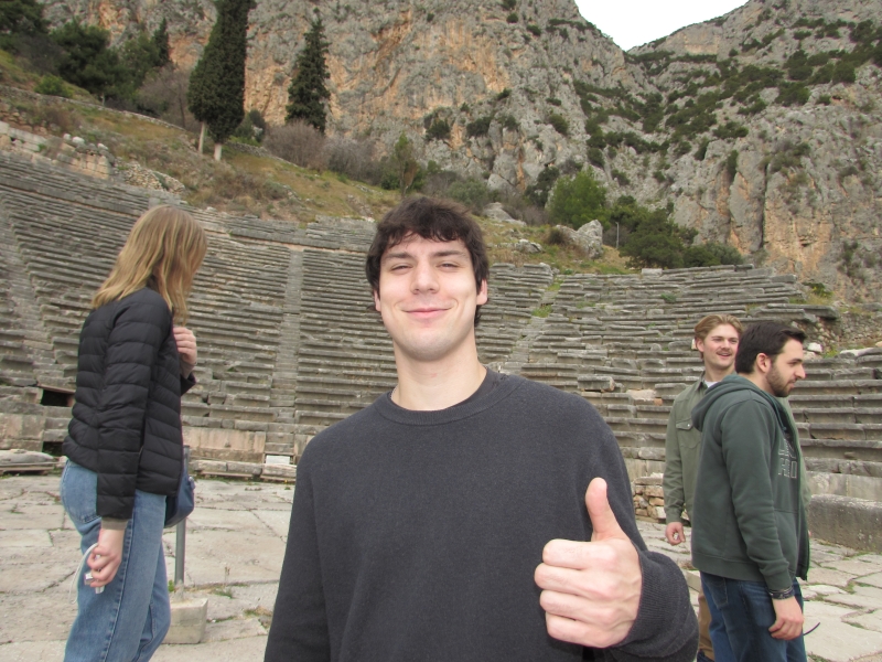 A boy in front of a greek theatre made of stone