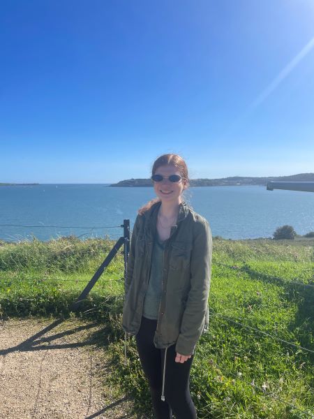 A students in front of the ocean on a cliff