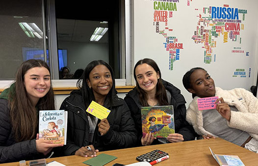 students with Spanish children's books and handmade letters at cultural event