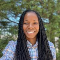 Jessica David smiling while wearing a plaid shirt