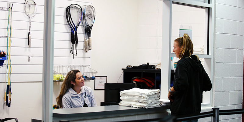 A student speaking to a student employee at the equipment rental room
