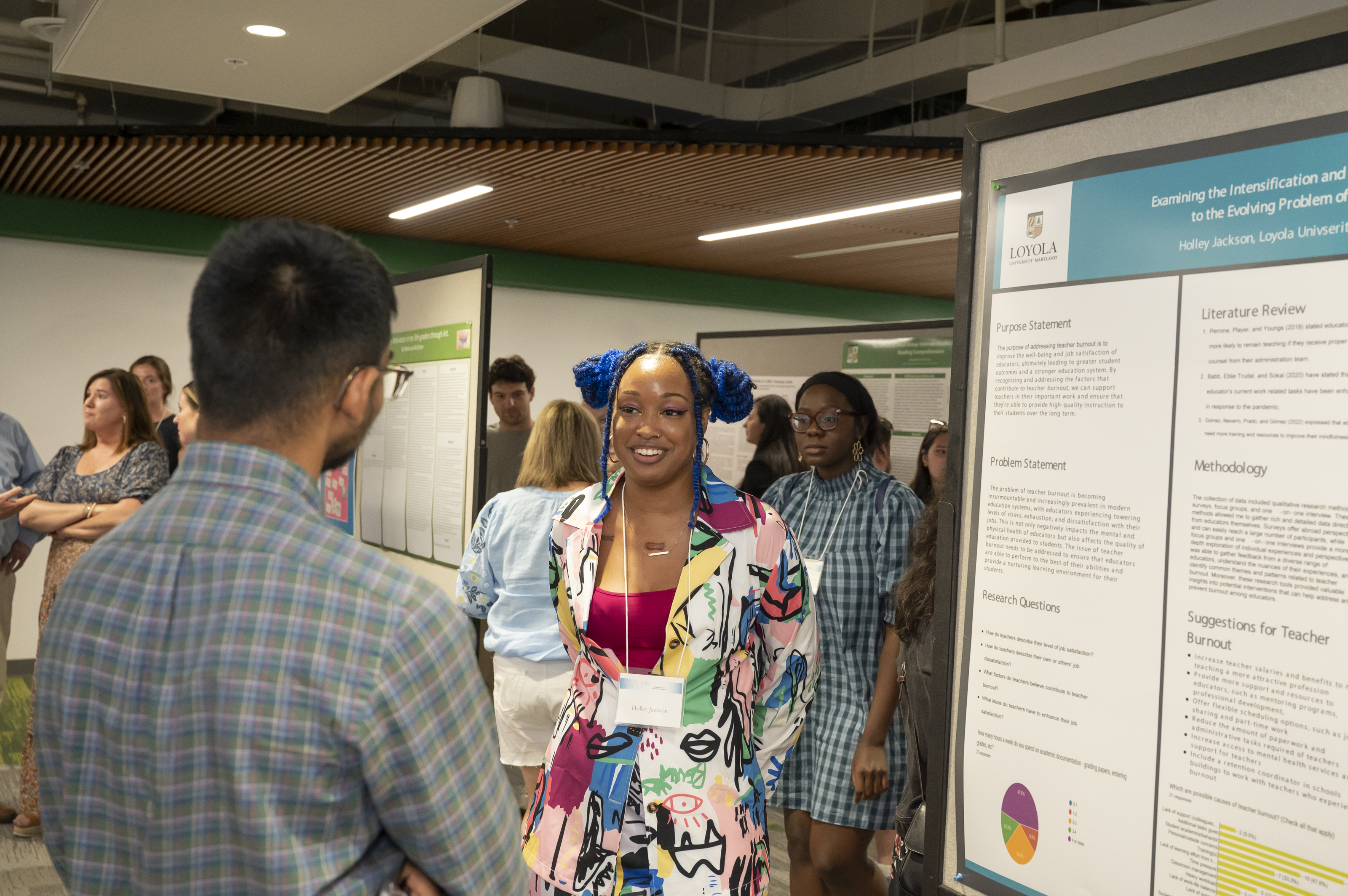 Presenter smiles while presenting poster at Emerging Scholars Loyola University Maryland