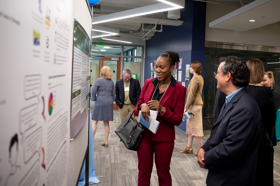 Graduate student explaining her research to administrator at Emerging Scholars 2024