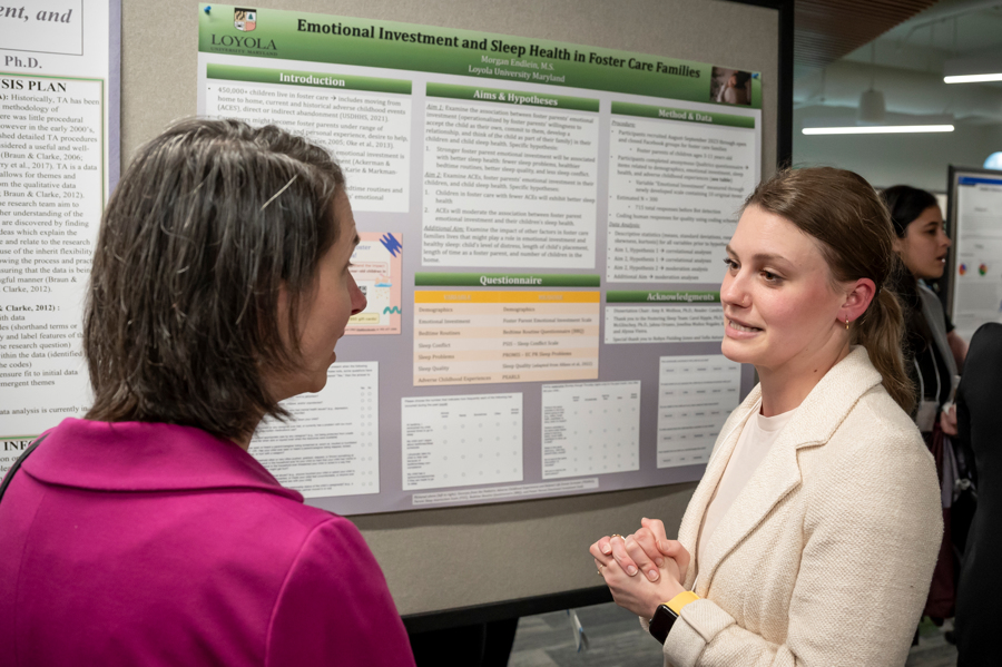 Graduate student discusses poster with faculty member at Emerging Scholars Loyola University Maryland