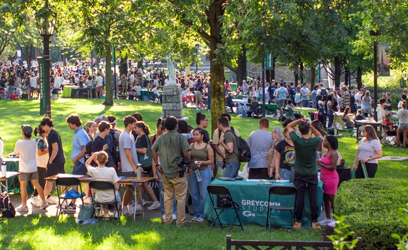 Students gather around tables on Loyola's quad for the activities fair