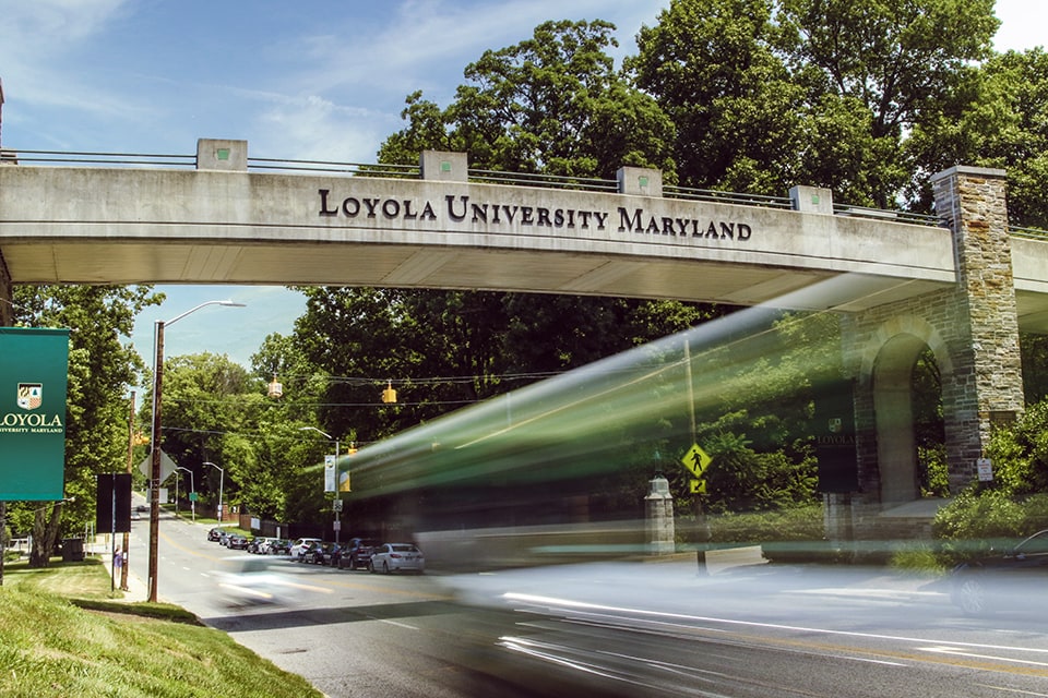 Ground view of a bridge with the words Loyola University Maryland written on the side