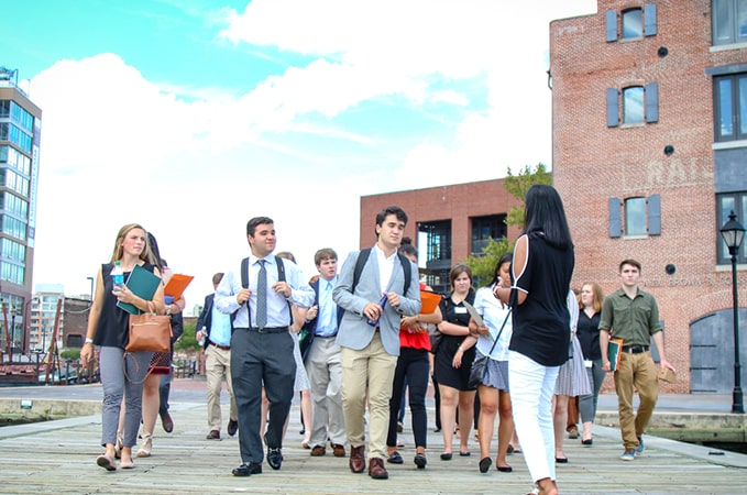Students walk with a company representative on a site visit on a pier in Baltimore harbor