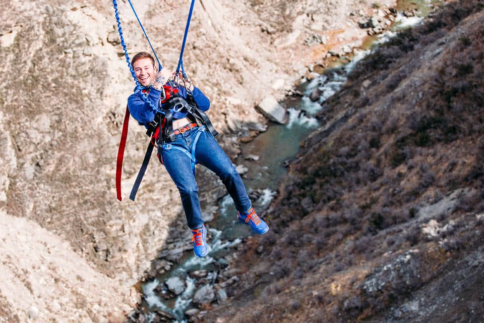 A student smiling while bungee jumping in New Zealand