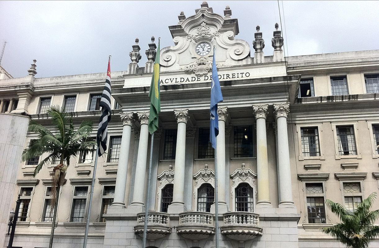Government building with Georgian style architecture in Chile flies three flags. in front of its colonnade entrance.