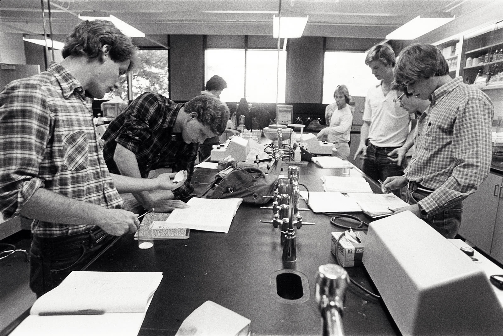 Vintage black and white photo of a group students working on a long table in Donnelly Science Center