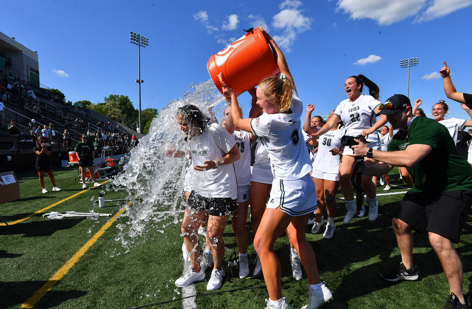 Loyola's women's lacrosse team celebrating a victory by dumping a Gatorade cooler on a player